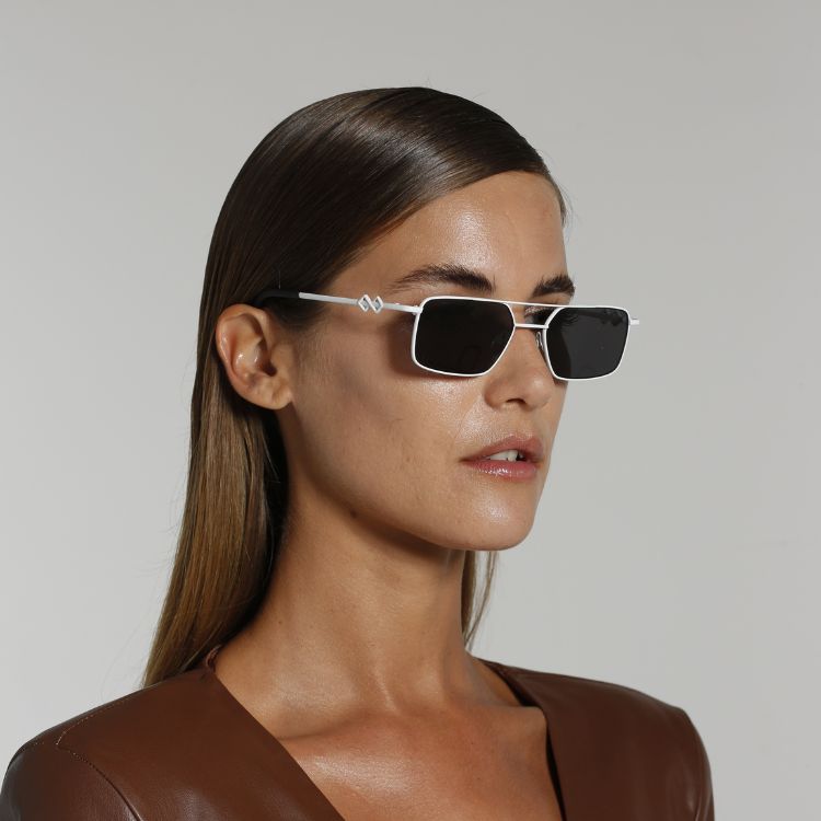 Side view of model wearing sunglasses | Rectangle sunglasses with black lenses and white frames | Metal | Devon | Women's, men's, and unisex sunglasses | Karen Wazen Eyewear