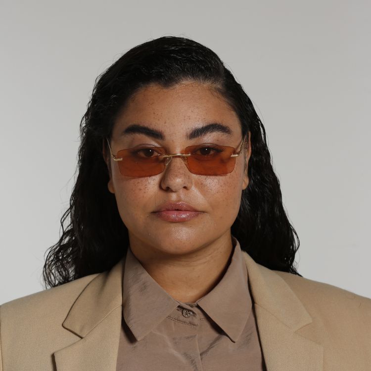 Front view of model wearing sunglasses | Frameless rectangle sunglasses with orange lenses and gold frames | Metal | Layla | Women's sunglasses | Karen Wazen Eyewear